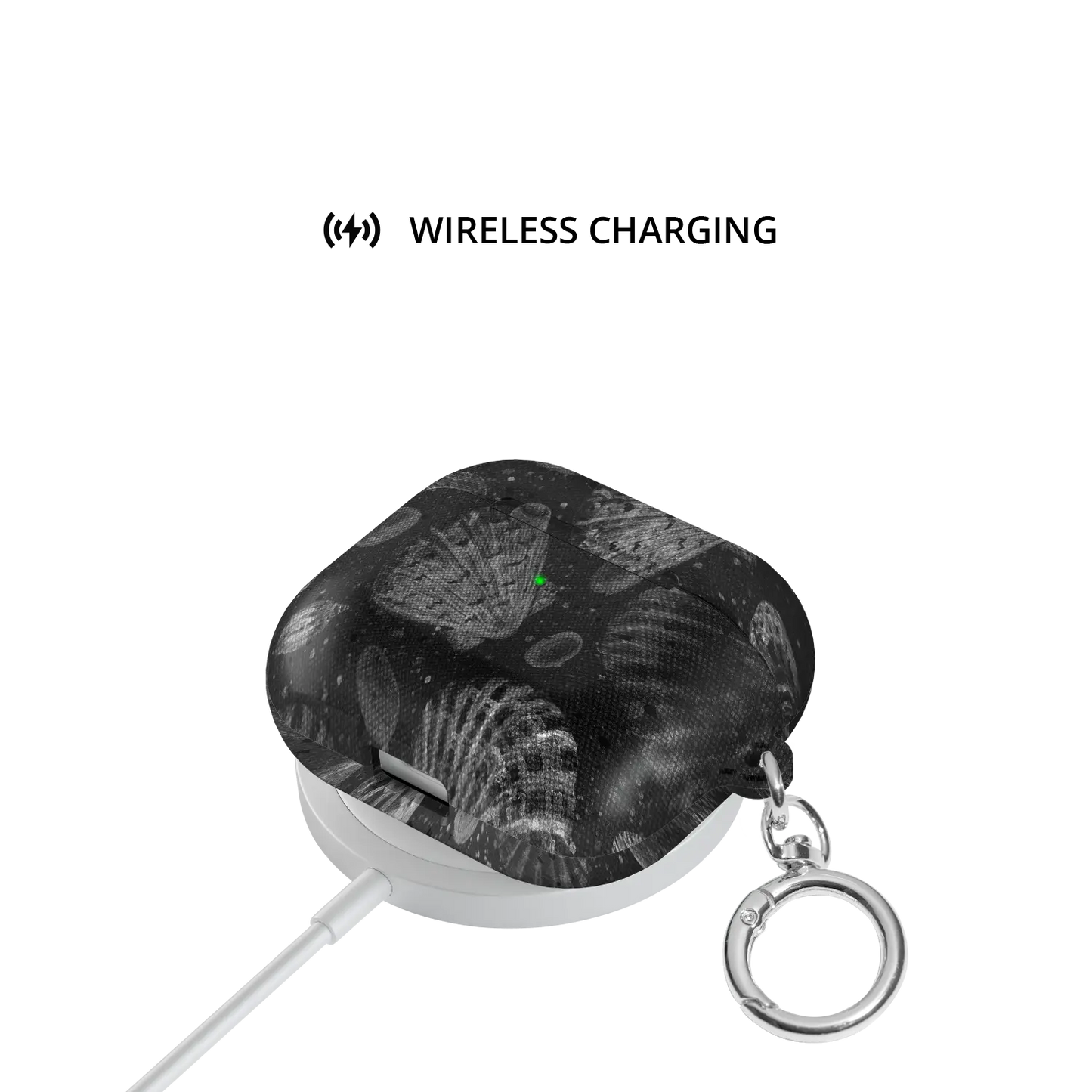 Moonlit Shells | Black Seashell AirPods Case - shown on wireless charger