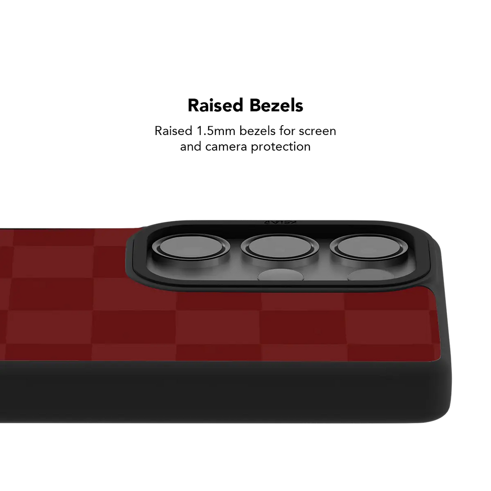Raised bezel on the burgundy checkerboard Galaxy case lifting the camera lenses clear of a flat surface
