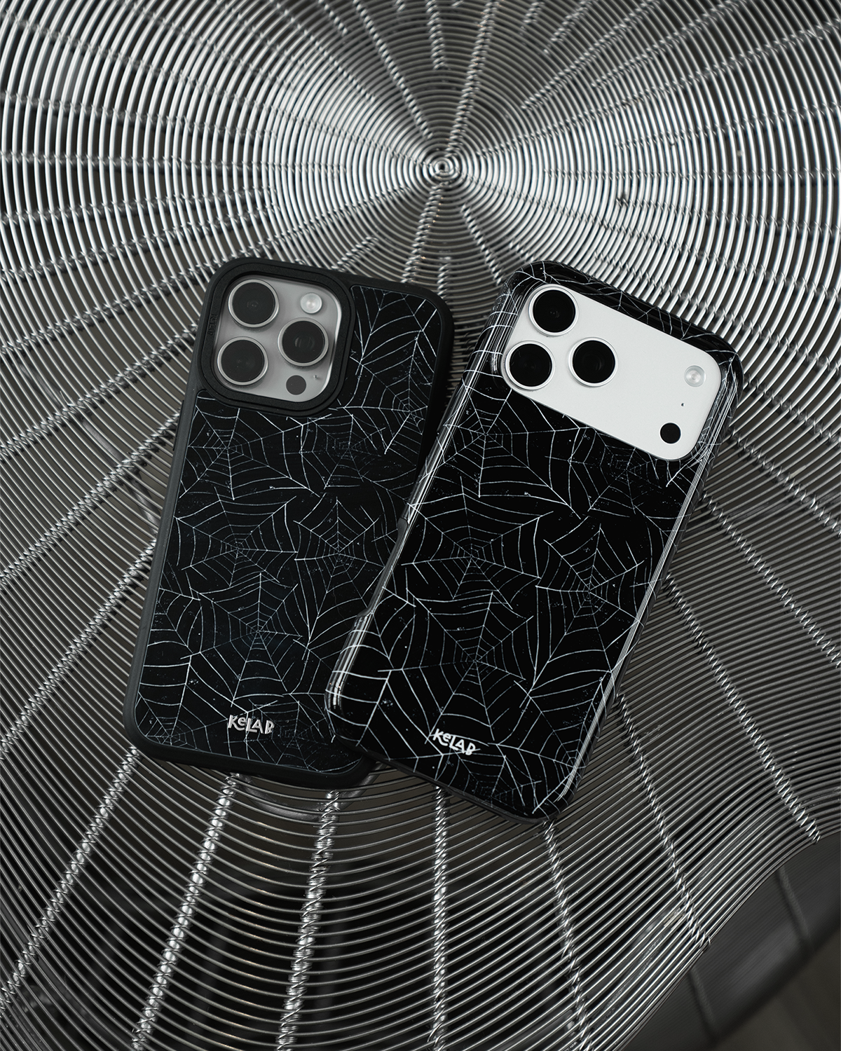 Black Spider Web iPhone case, two cases shown together on a spider web-patterned surface