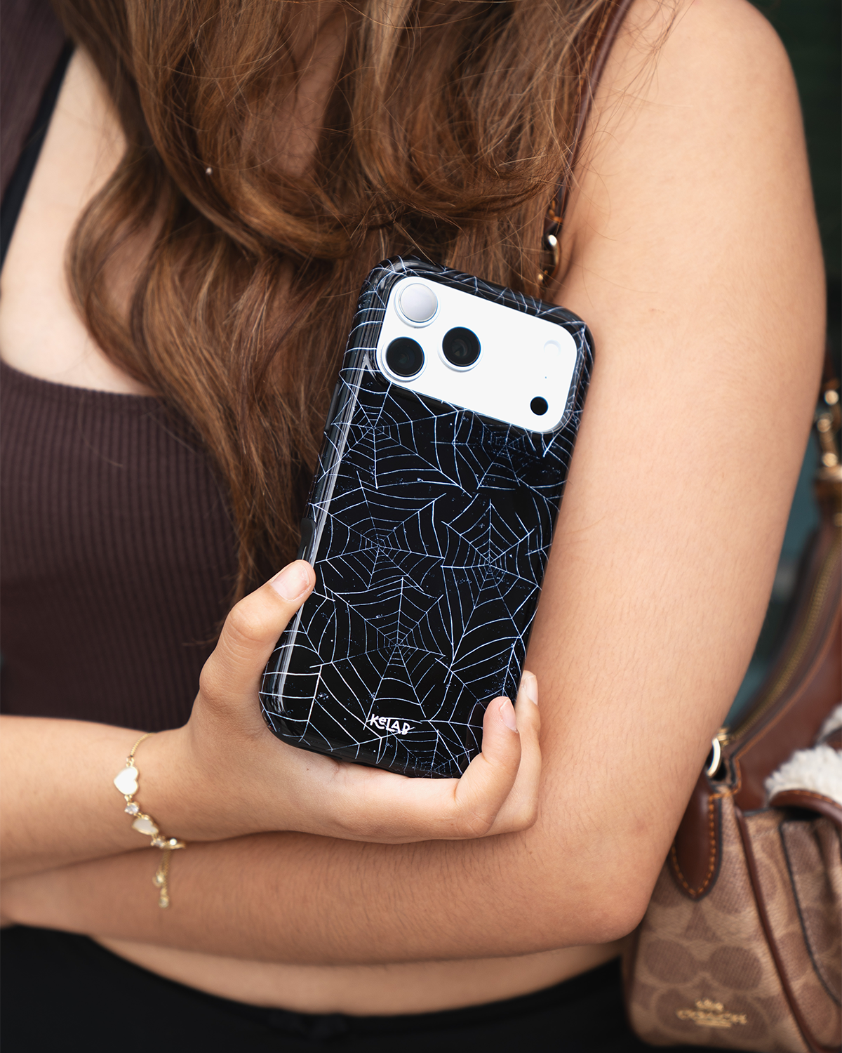 Black Spider Web iPhone case, in-hand lifestyle shot