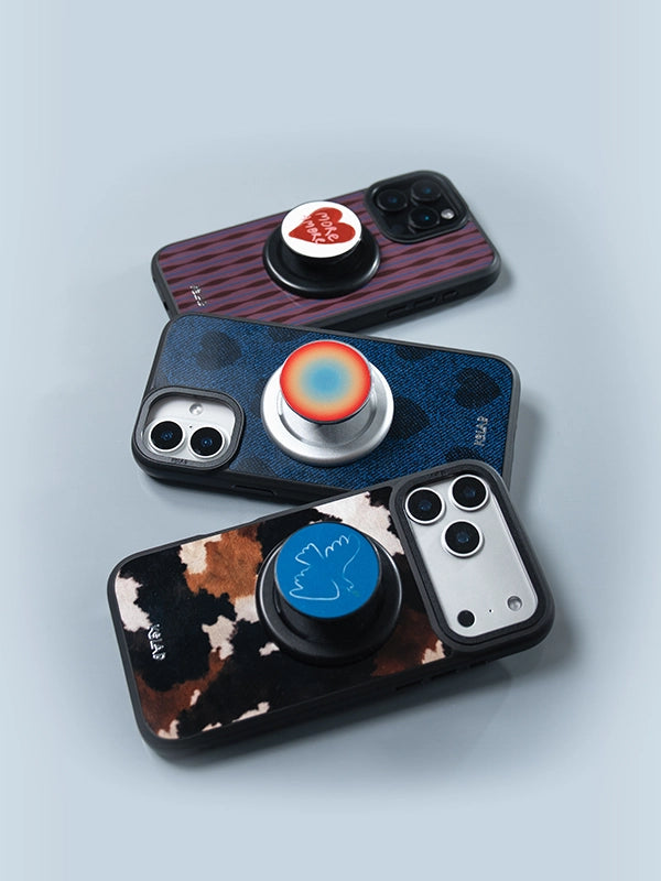 Three phone cases with pop sockets on a light gray background
