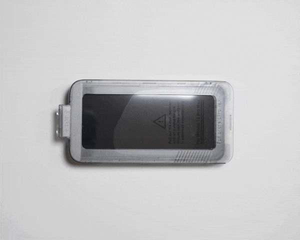 A screen protector placed inside an easy install tray on a light surface.