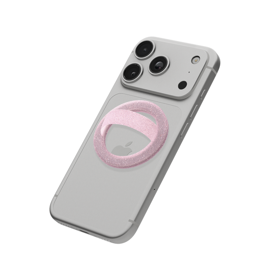 Pink glitter MagSafe loop grip attached to the back of an iPhone
